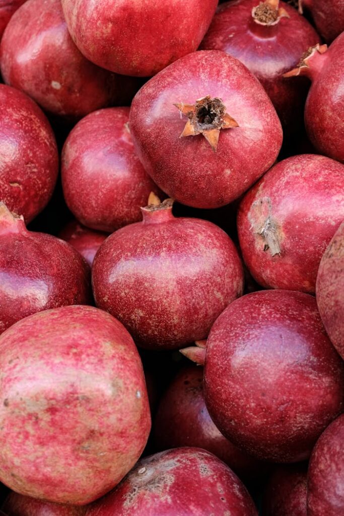 Lush, red pomegranates in a stacked arrangement. Ideal for food and freshness concepts.